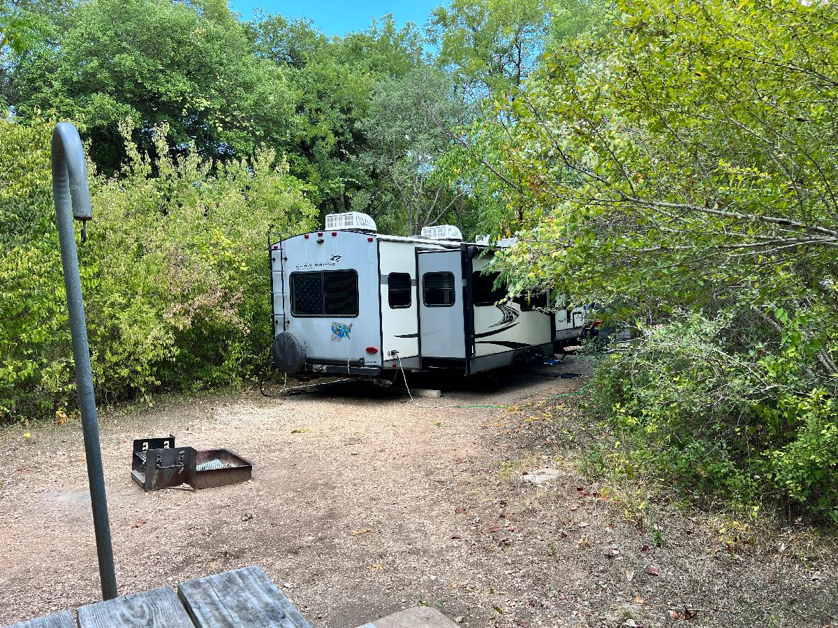 Private Campsite: Travel Trailer Peeking Through the Trees